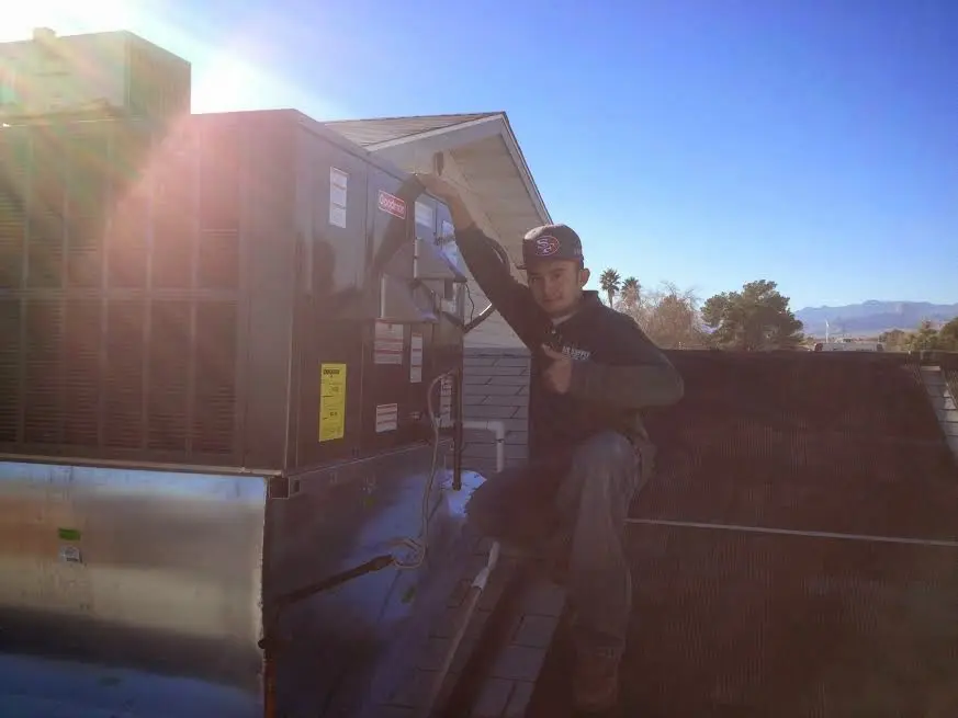 HVAC technician performing AC Tune-Up on a rooftop unit in Ridley Park
